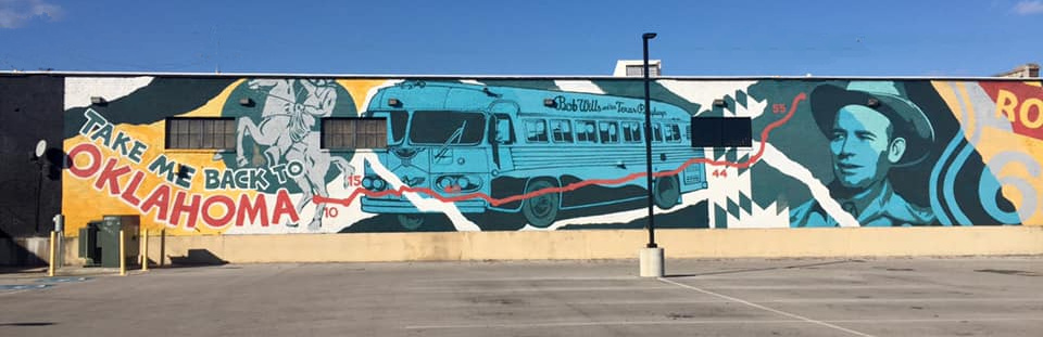 A mural on the side of a building with a bus on it.