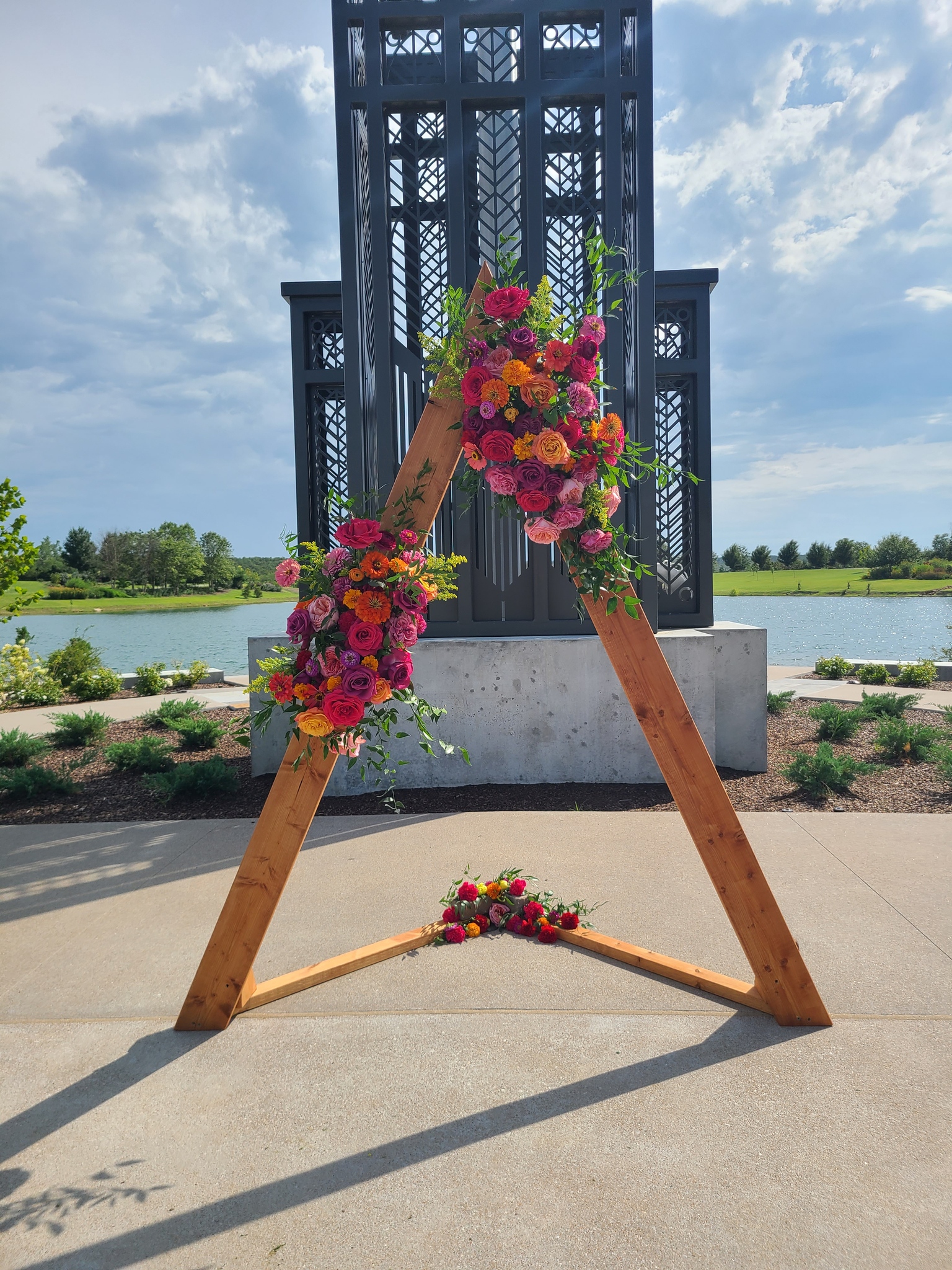 A wooden triangular structure with flowers on it.