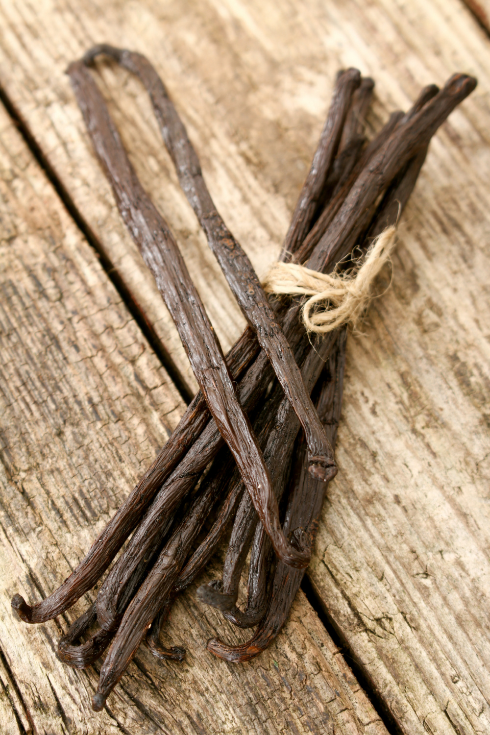 A bunch of vanilla beans on a wooden table.