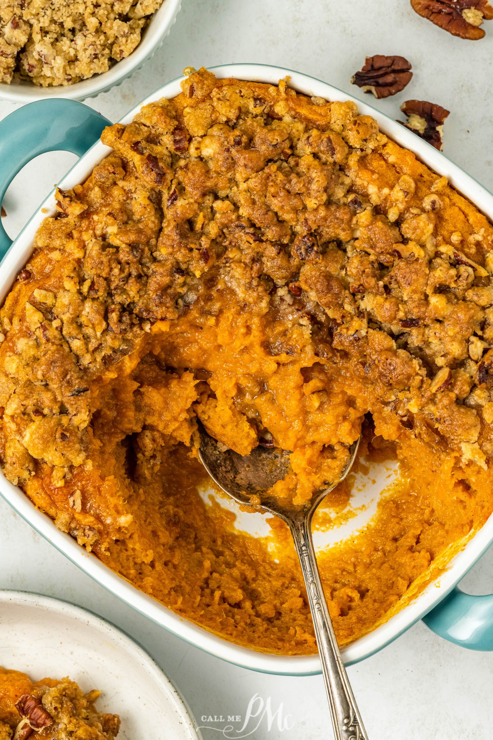 Sweet potato souffle in a white dish with a spoon.