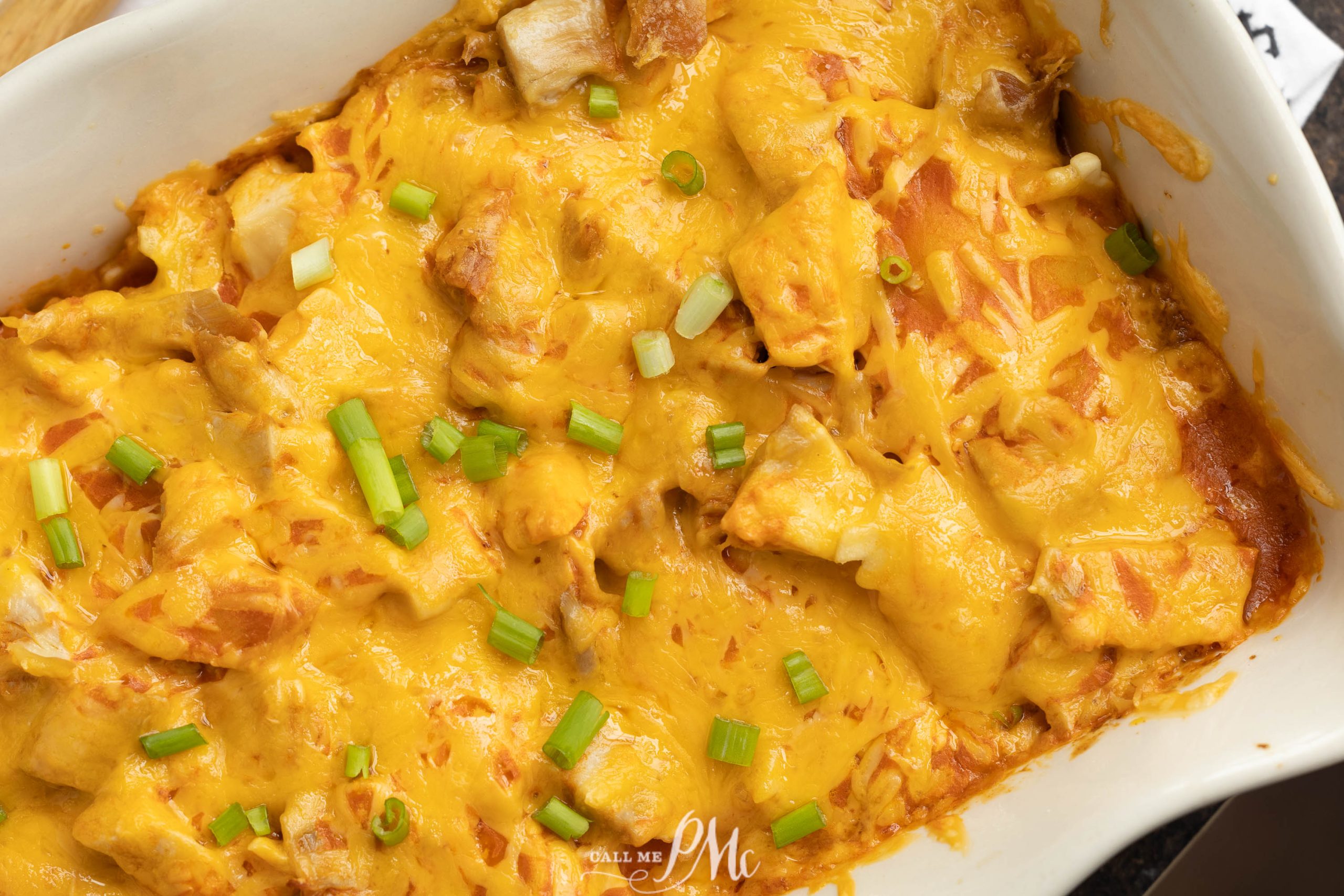 Cheesy chicken casserole in a white dish.