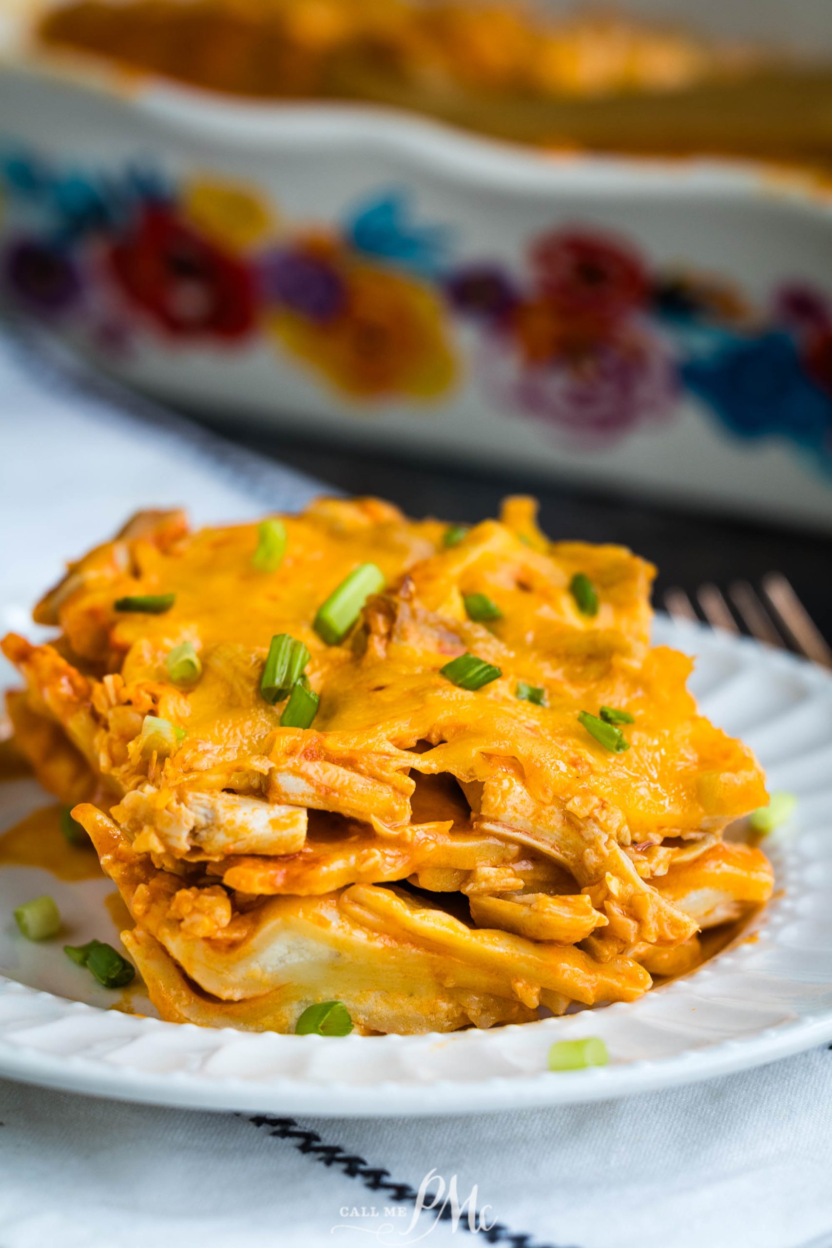 A plate of chicken enchilada casserole on a white plate.