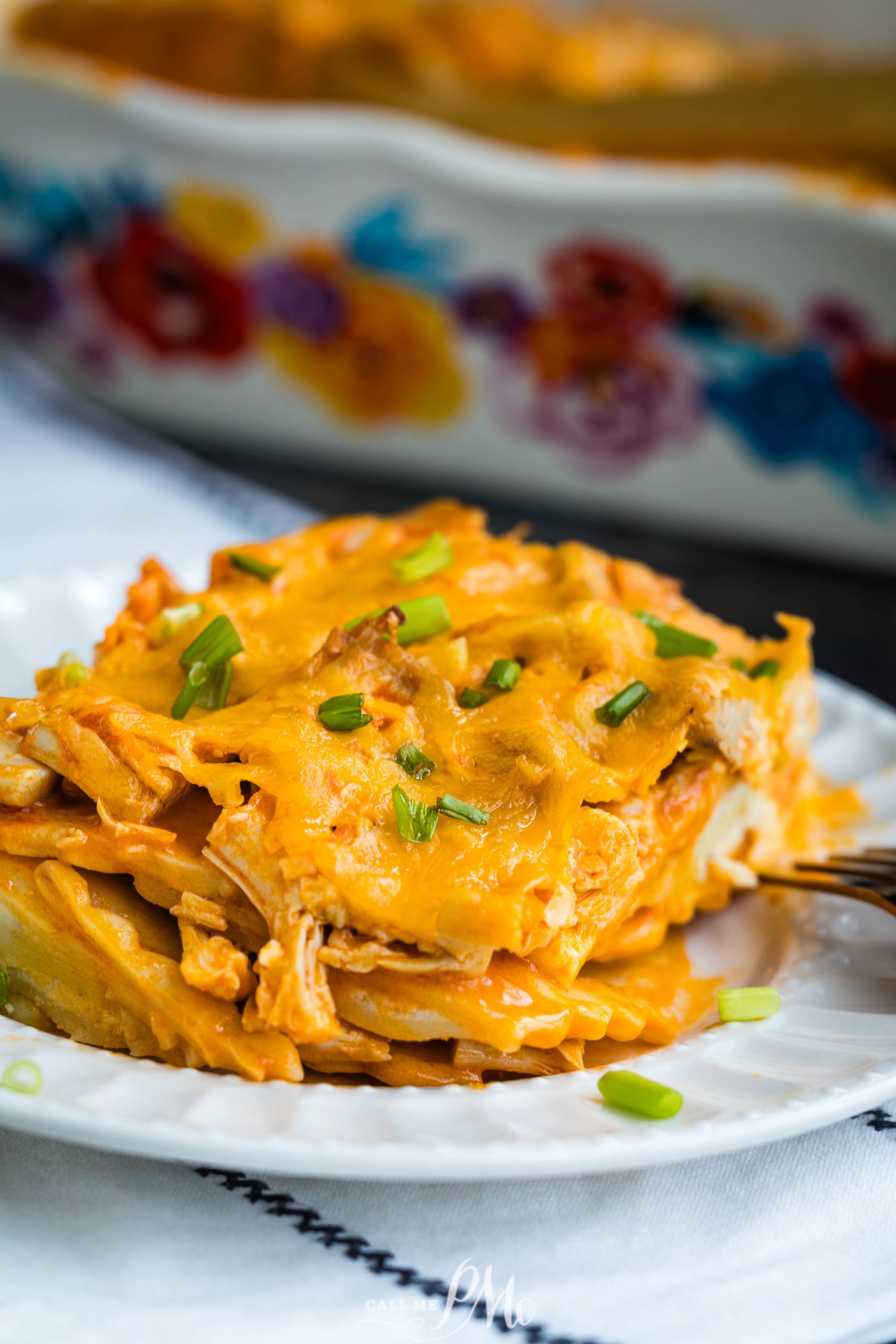 Chicken enchilada casserole on a plate with a fork.