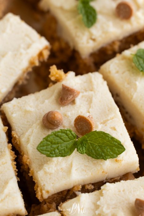 A plate of square cookies with mint leaves on top.