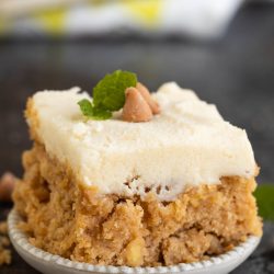 A piece of cake on a plate with a mint leaf on top.