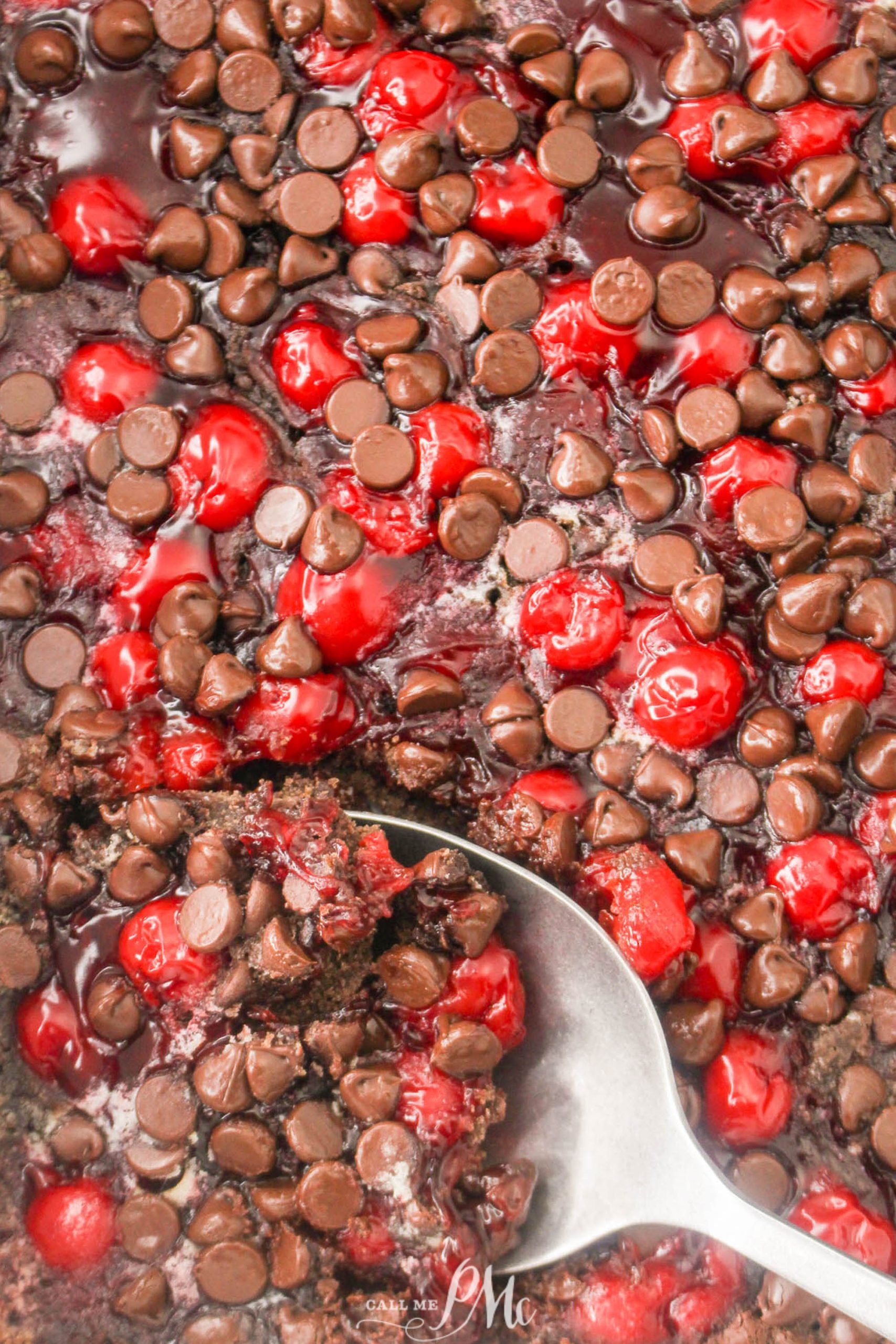 A spoonful of cherry chocolate chip cookie dough in a baking dish.