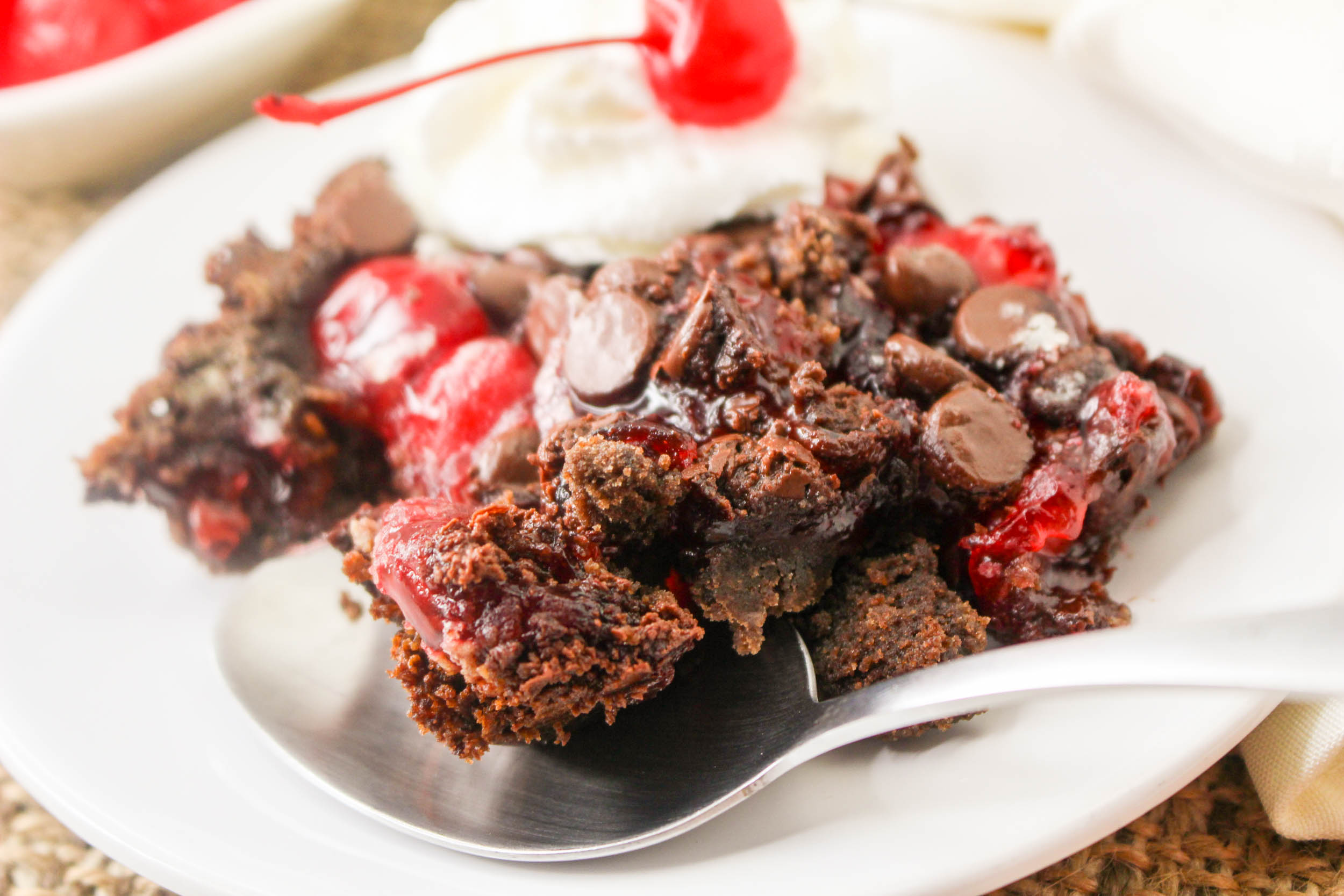 A piece of chocolate cherry brownie pie on a plate.