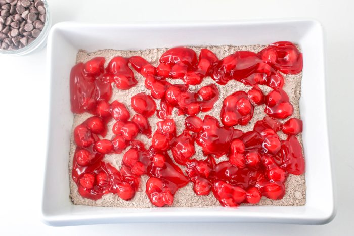 A square baking dish with cherries and chocolate chips.