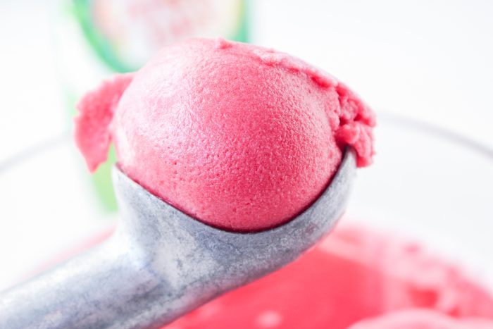 A scoop of pink ice cream in a bowl.