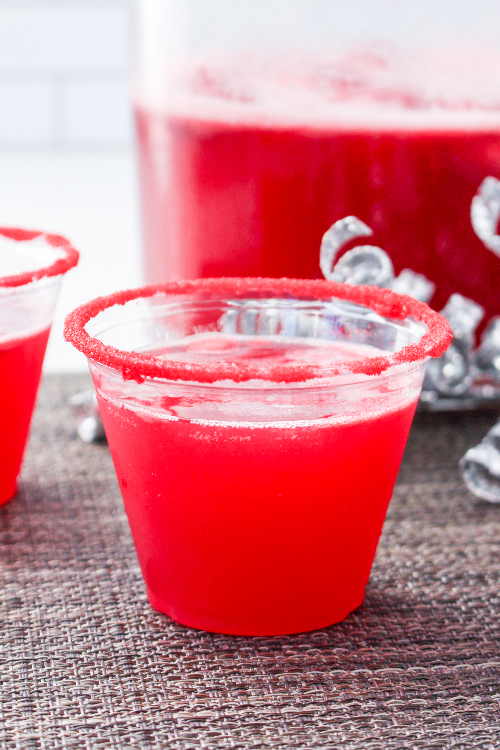 Two cups with red liquid in them on a table.