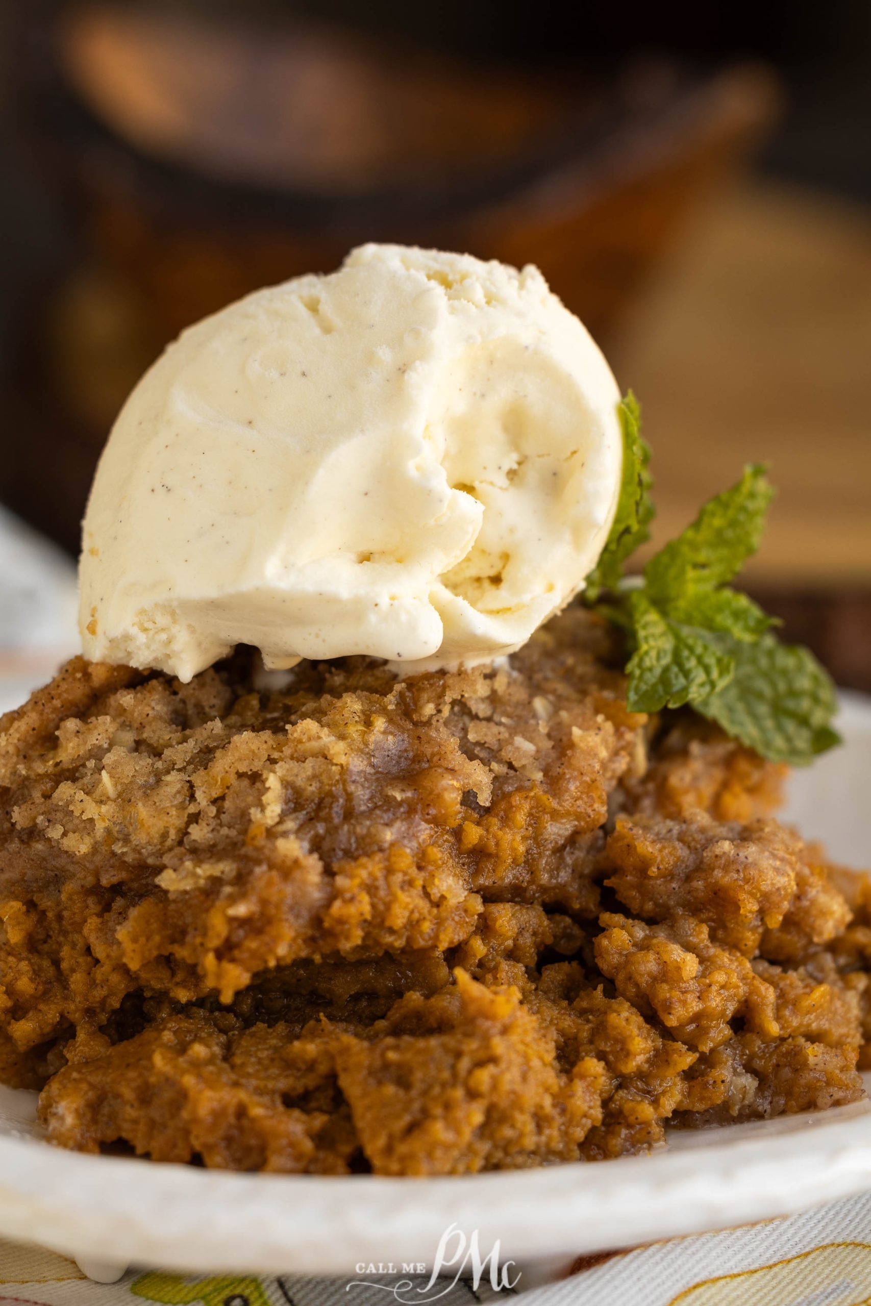 A plate of pumpkin cobbler with ice cream on top.