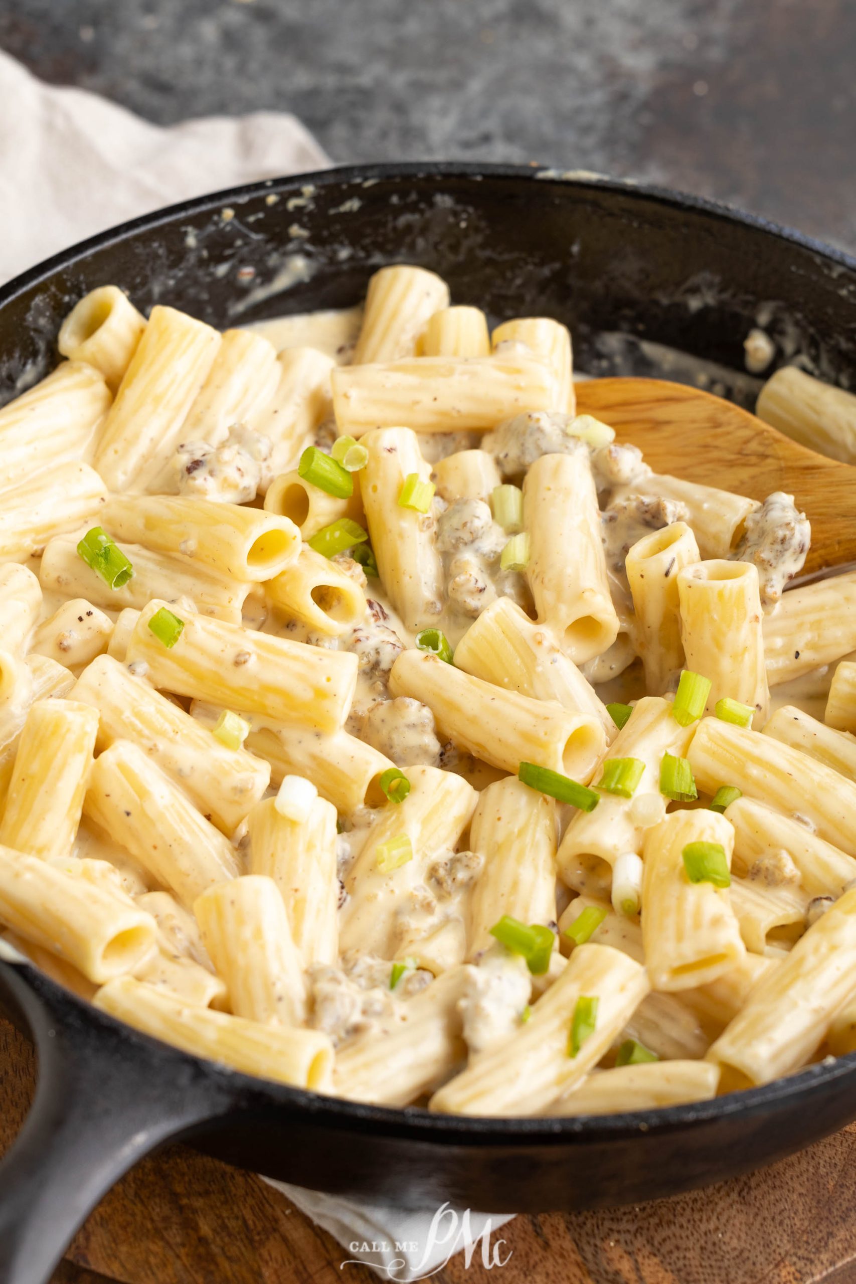Hissy Fit Dip Pasta Recipe has penne pasta in a skillet with cheese and green onions.