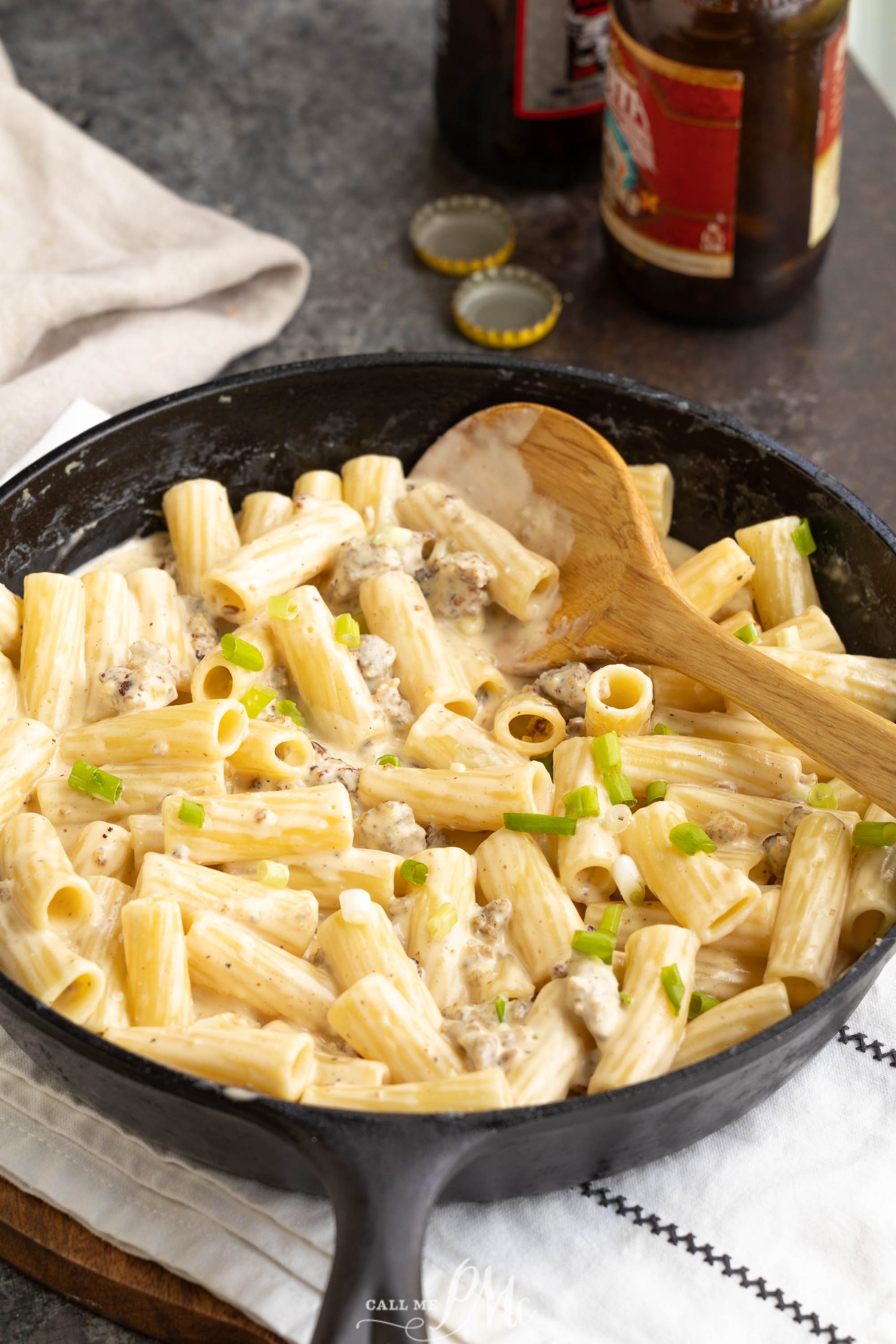 A skillet full of pasta with cheese and meat in it.