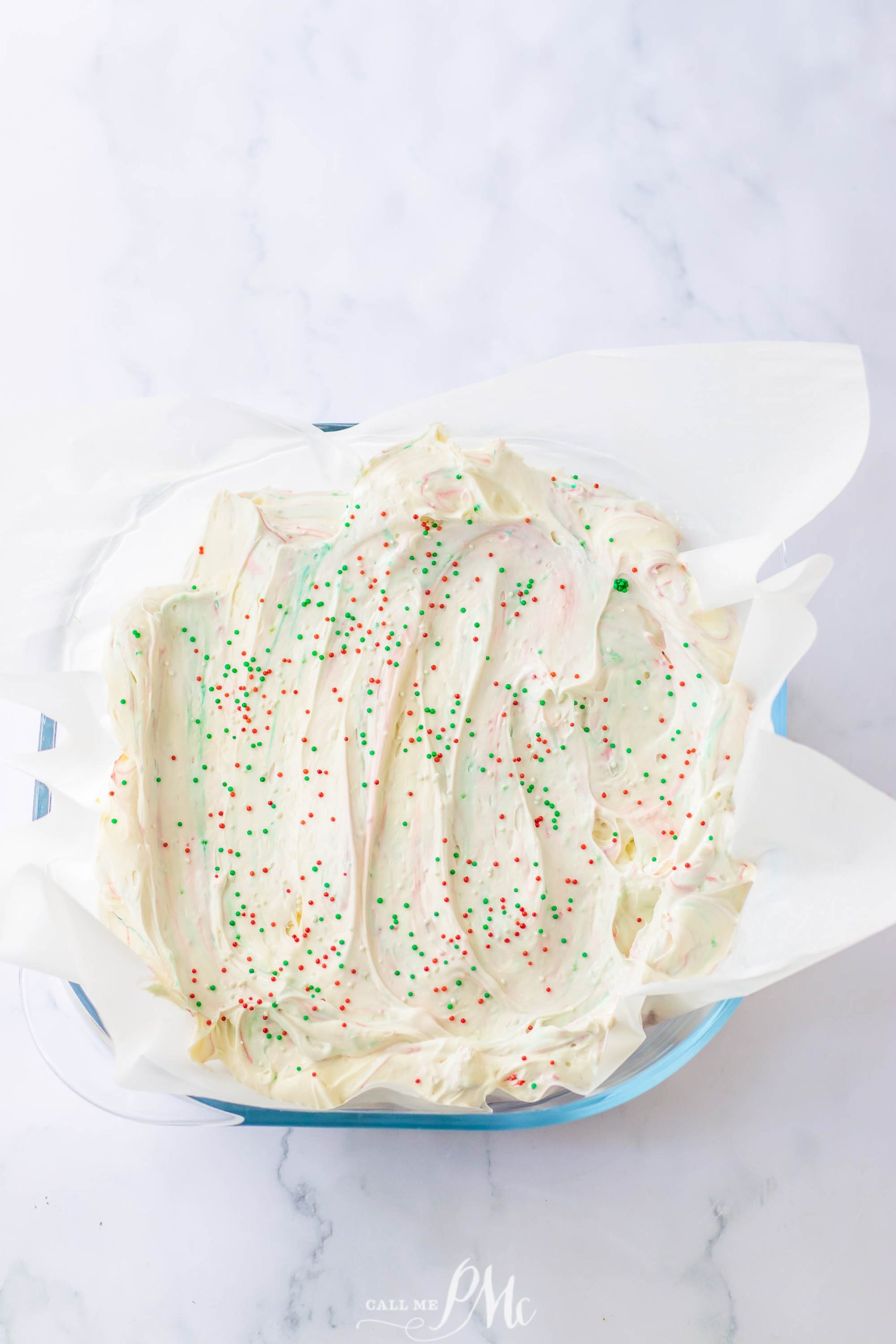 A bowl of icing with sprinkles on it for Funfetti Crunch Cake