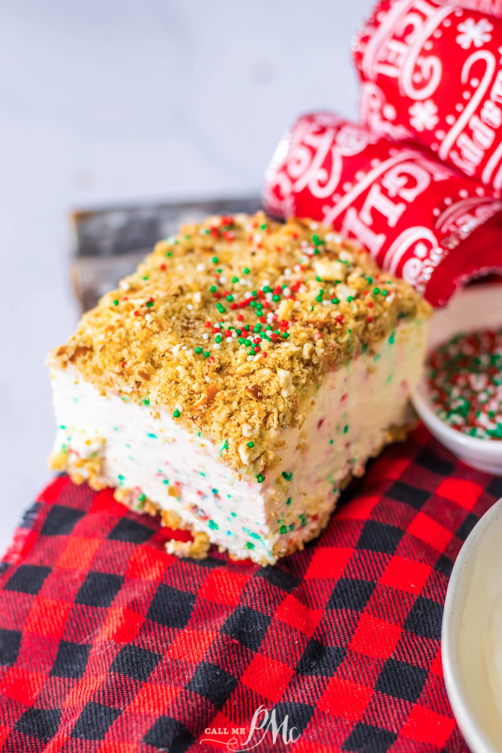 A piece of ice cream cake on a red and white checkered tablecloth.