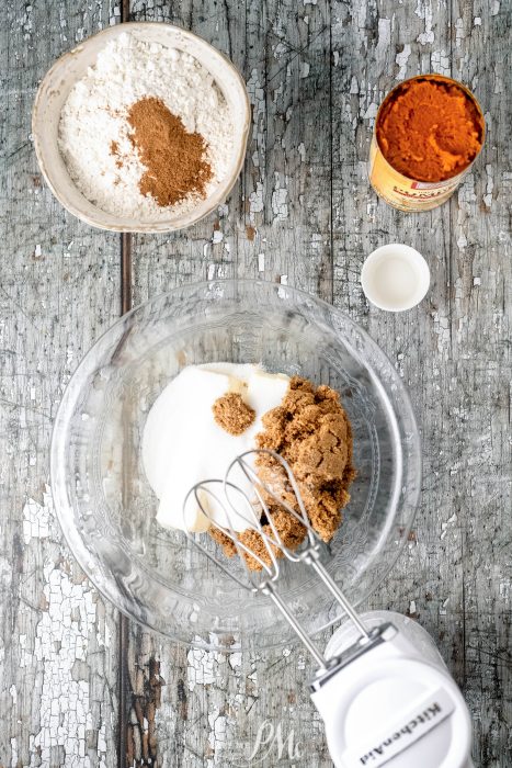 Ingredients for a pumpkin blondie in a bowl on a wooden table.