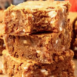 A stack of pumpkin brownies on top of a piece of paper.