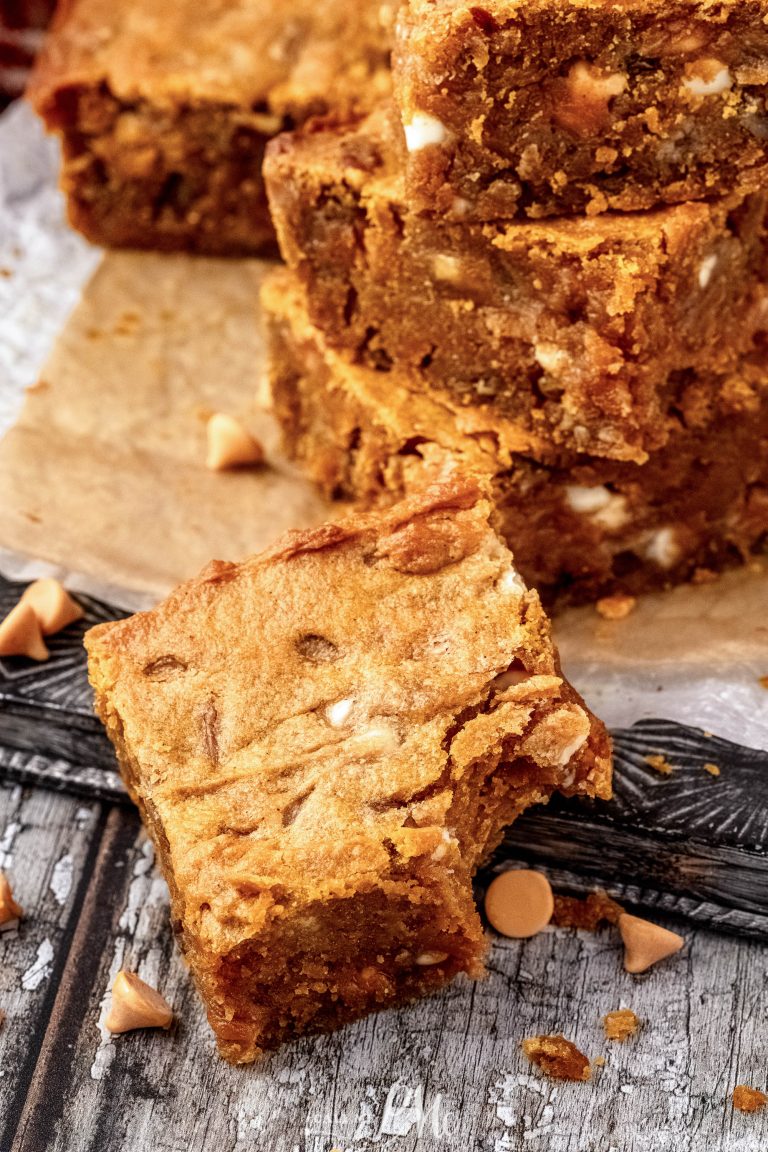 A stack of pumpkin brownies on a cutting board.
