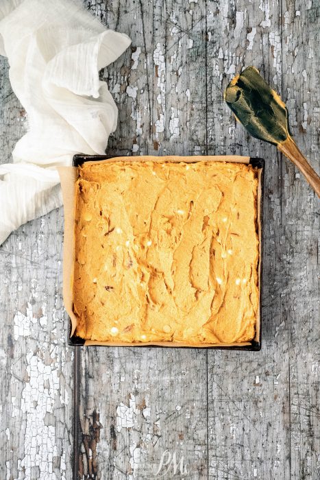 A square of pumpkin bread in a box on top of a wooden table.