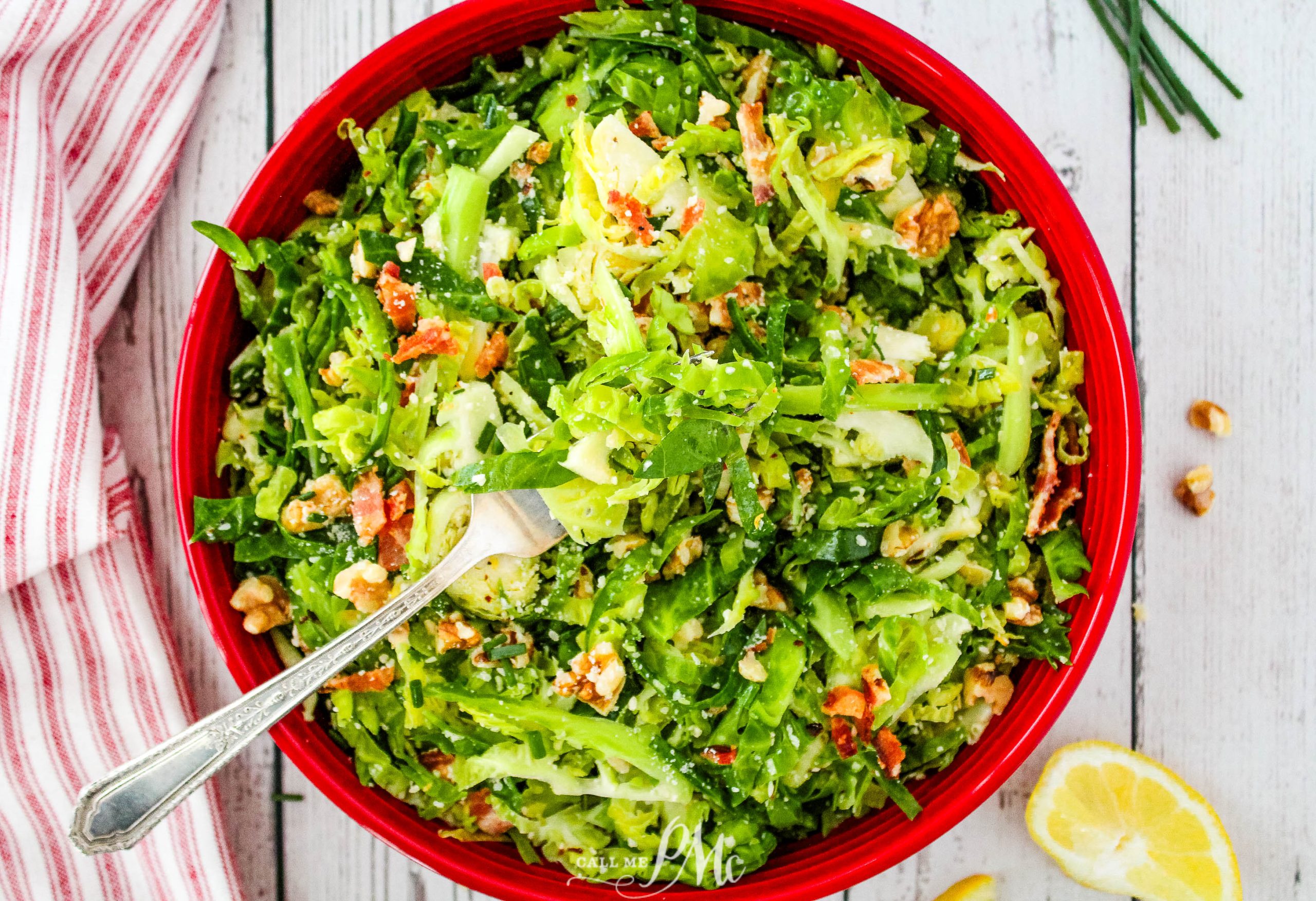 A red bowl with a salad in it.