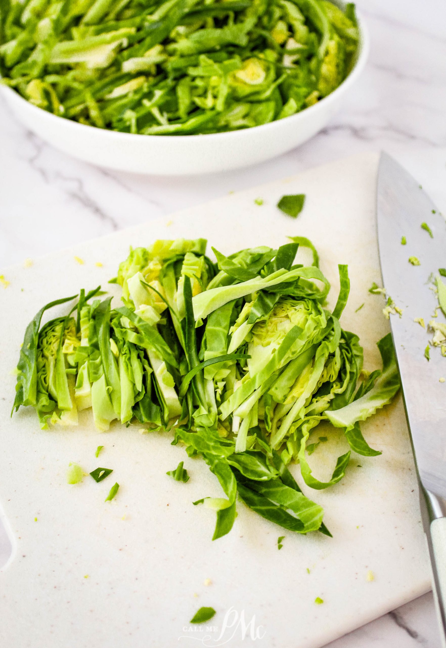 Brussel sprouts on a cutting board with a knife.