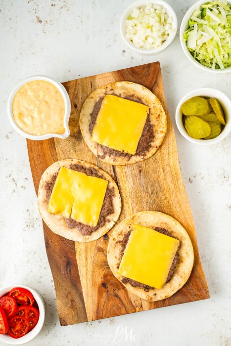 Four tacos on a wooden cutting board.