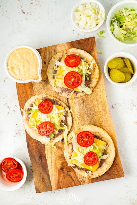 Three Viral Smash Burger Tacos on a wooden cutting board.