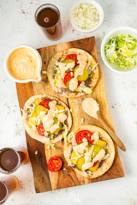 Three Viral Smash Burger Tacos on a wooden cutting board.