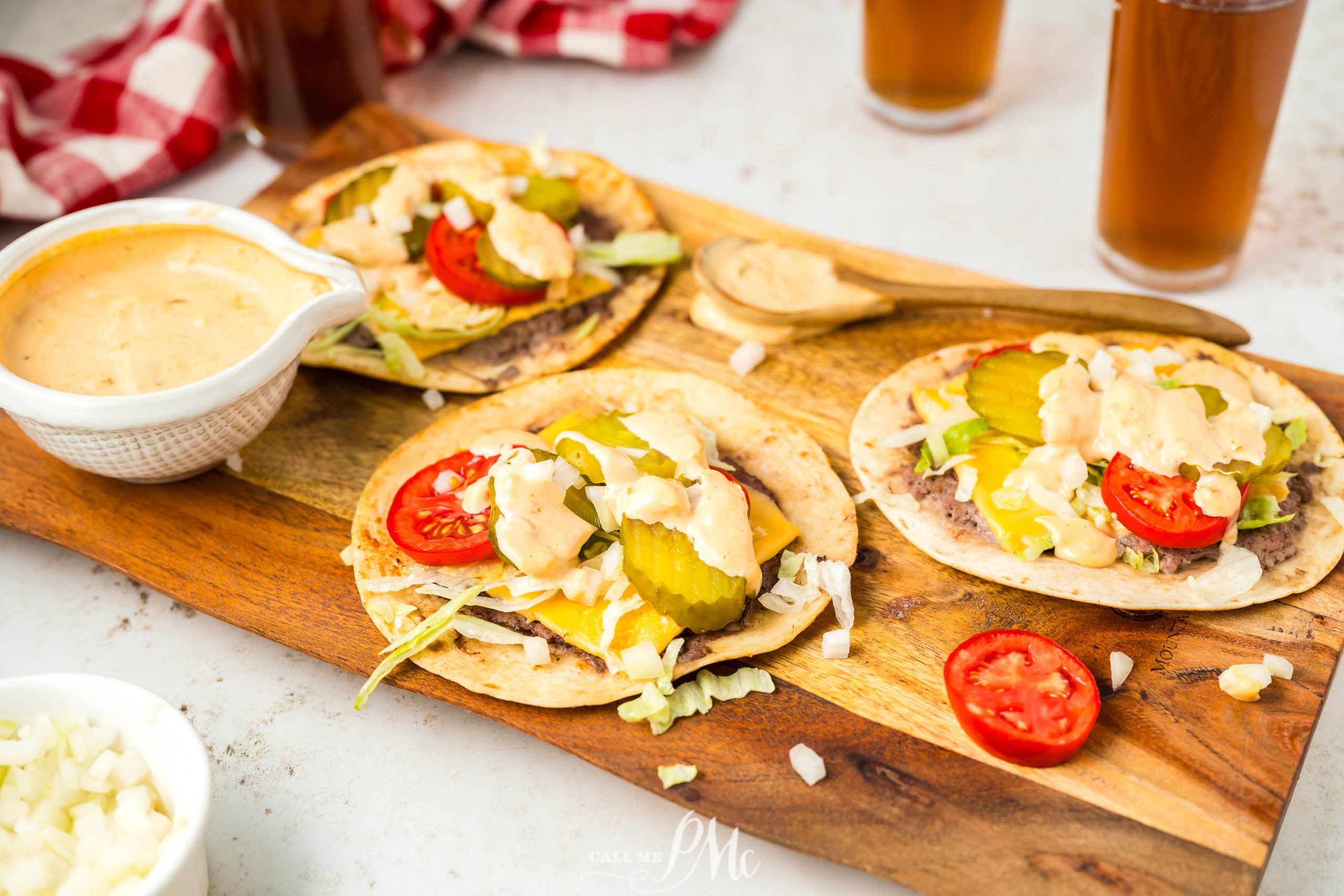 Three tacos on a wooden cutting board.