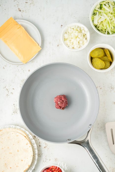 A frying pan with meat and vegetables on it.