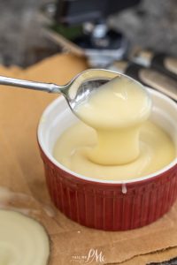 A spoon is pouring a sauce into a bowl.