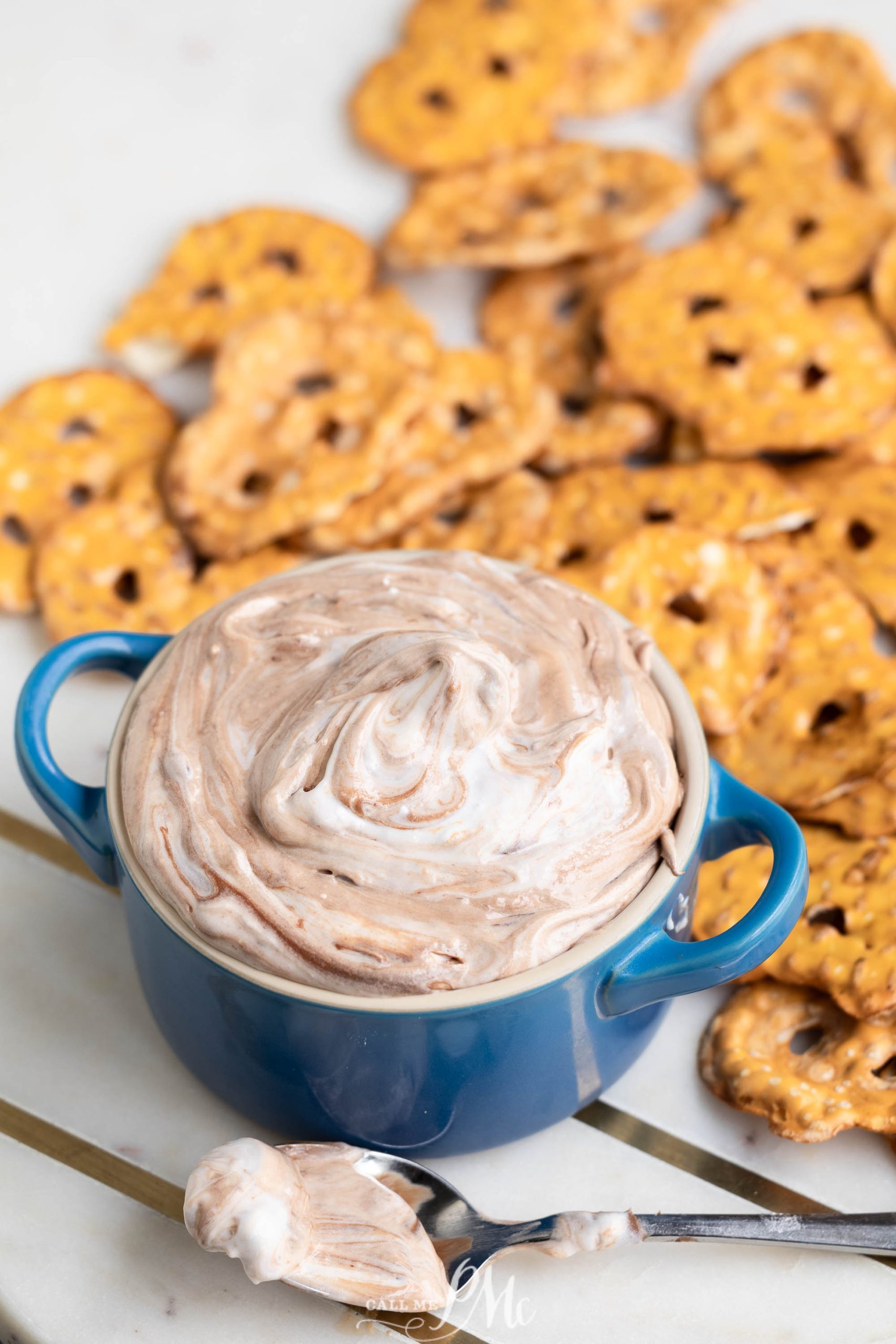 dessert in a blue bowl surrounded by pretzels.