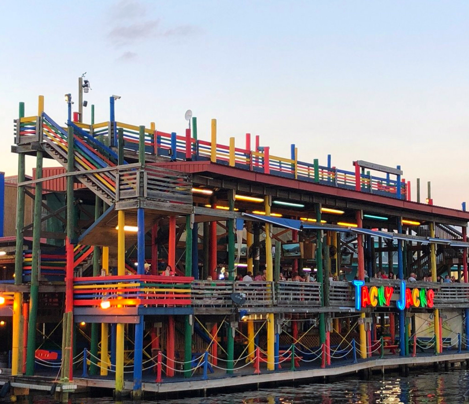 A boat docked in the water with a colorful building.