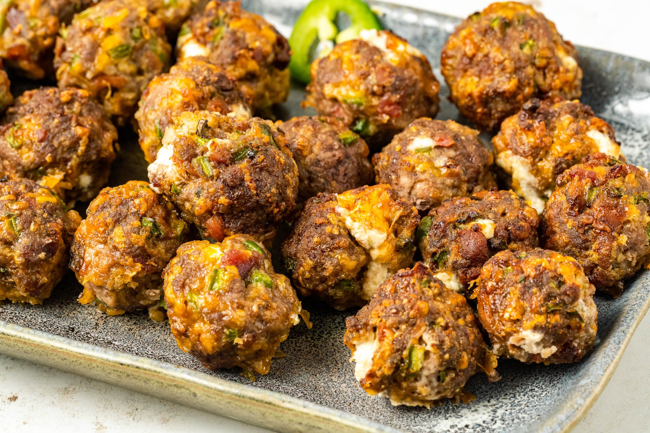Meatballs on a plate with jalapenos.