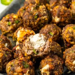 Meatballs with cheese and jalapenos on a plate.