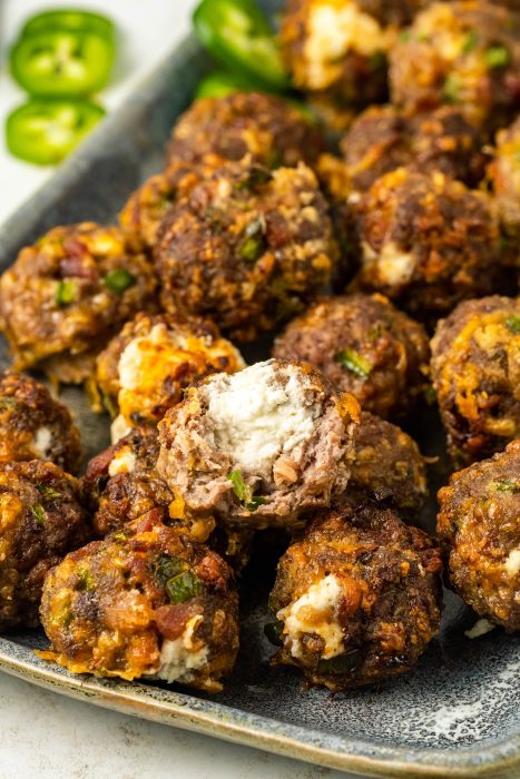 Meatballs with cheese and jalapenos on a plate.