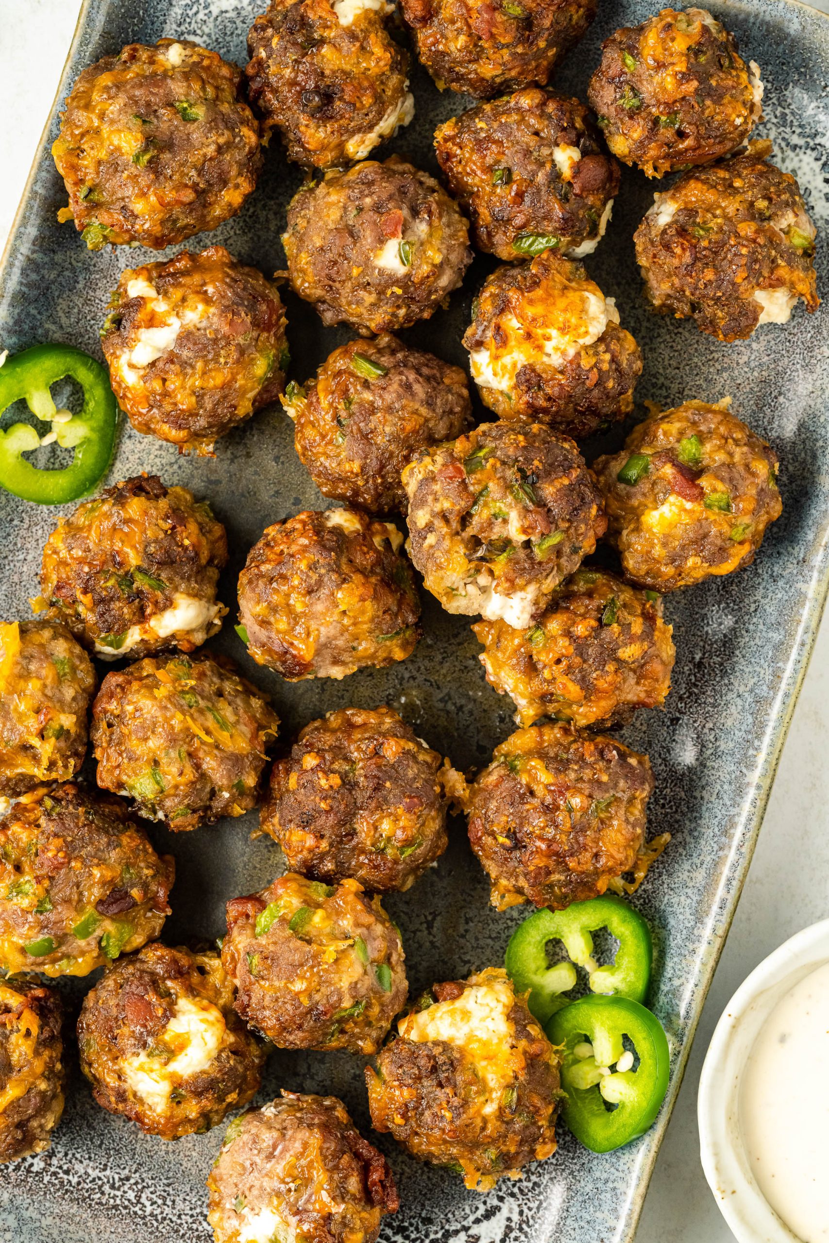 Jalapeno Popper Meatballs on a tray with dipping sauce.