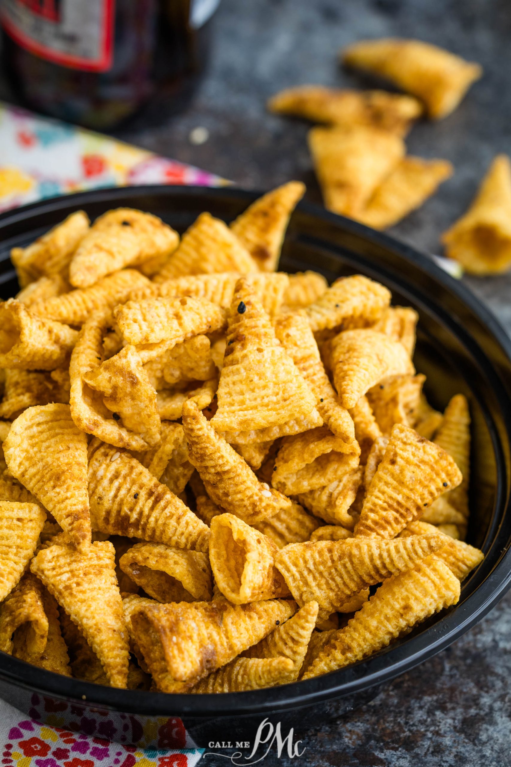 Bugles in a bowl with a bottle of beer.