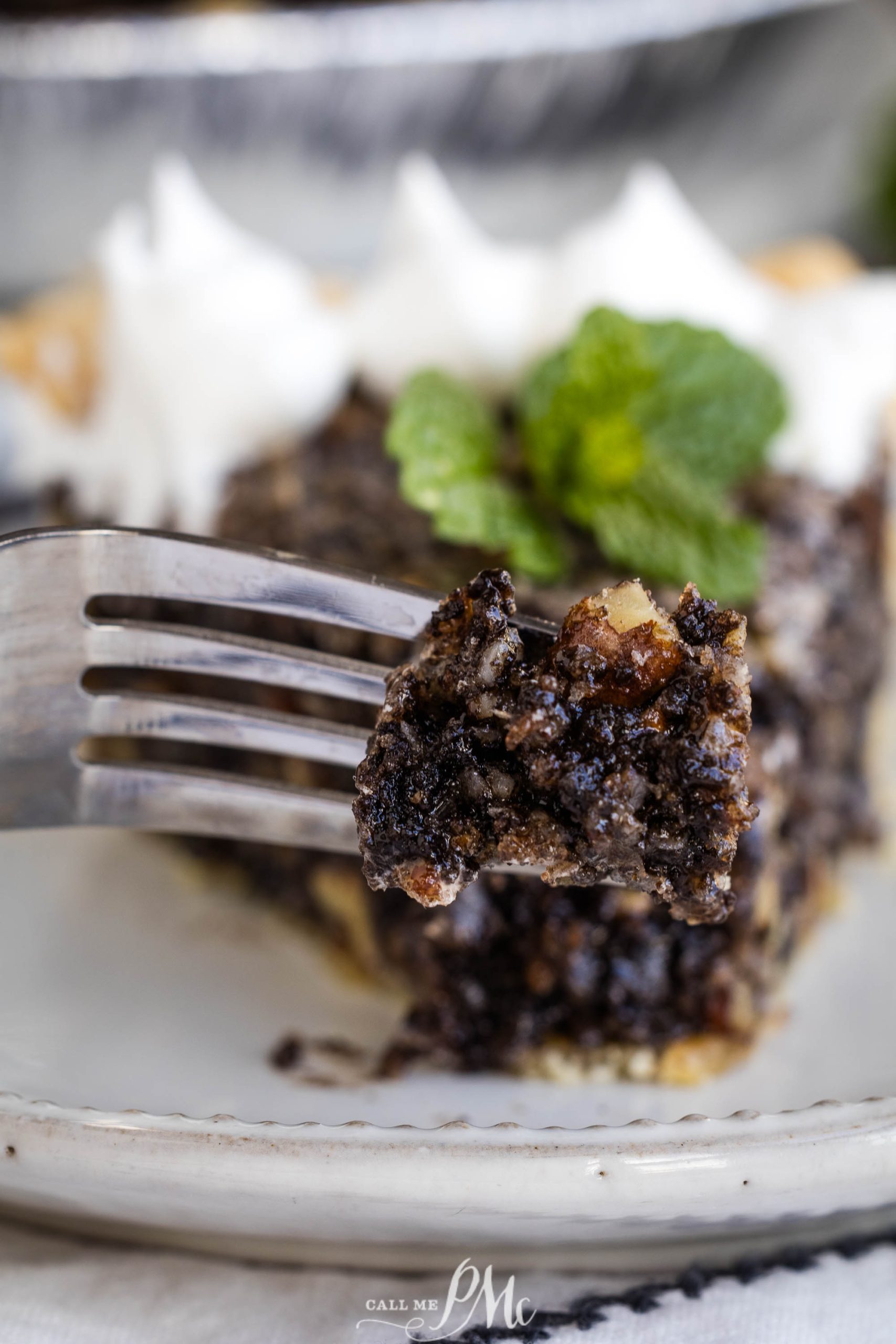 A slice of chocolate pie on a plate with a fork.