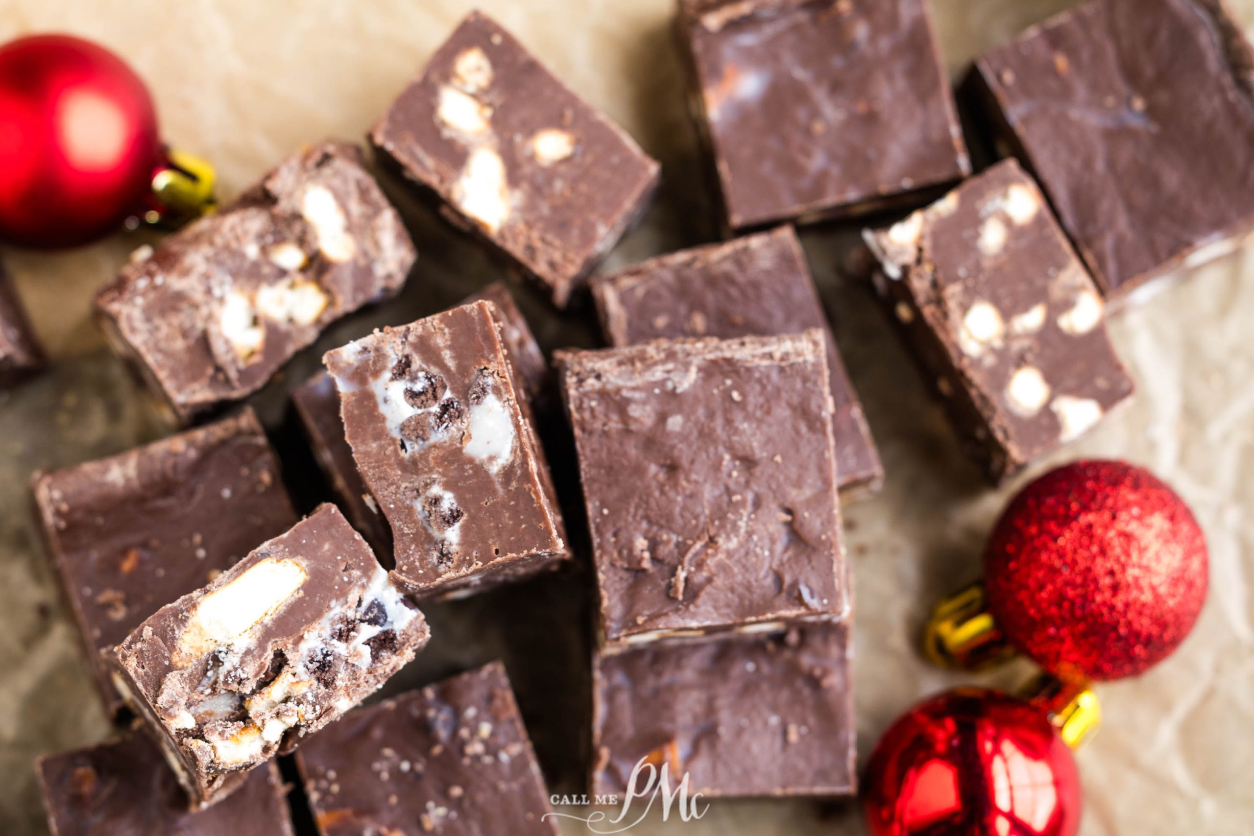 A pile of chocolate fudge with christmas ornaments on top.