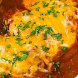 Chicken enchiladas in a crock pot with cheese.
