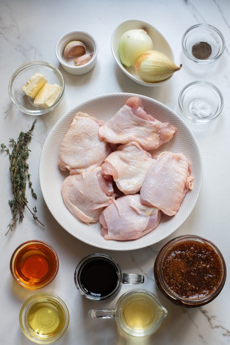 A plate with chicken breasts and other ingredients on it.