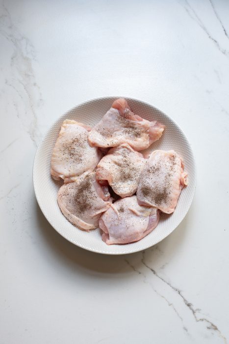 Fresh chicken breasts on a white plate.