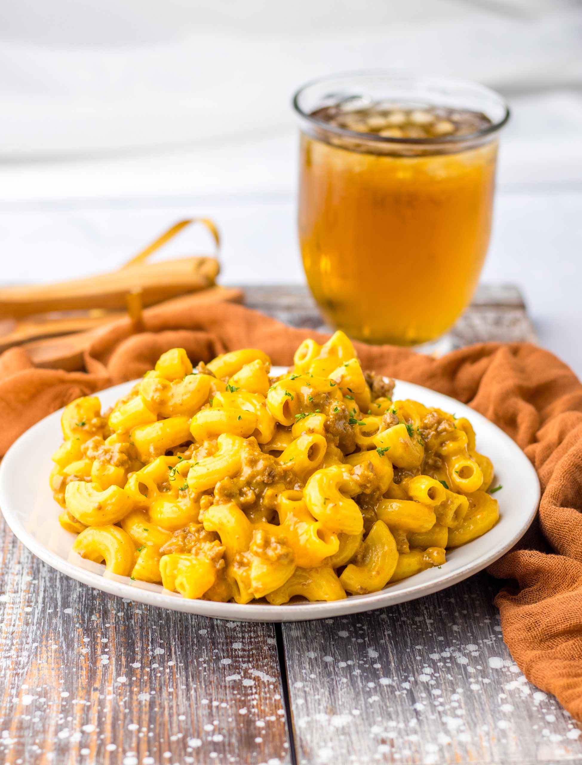 A plate of One Pot Cheesy Beef Macaroni on a wooden table.