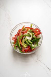 A bowl filled with red and green peppers.