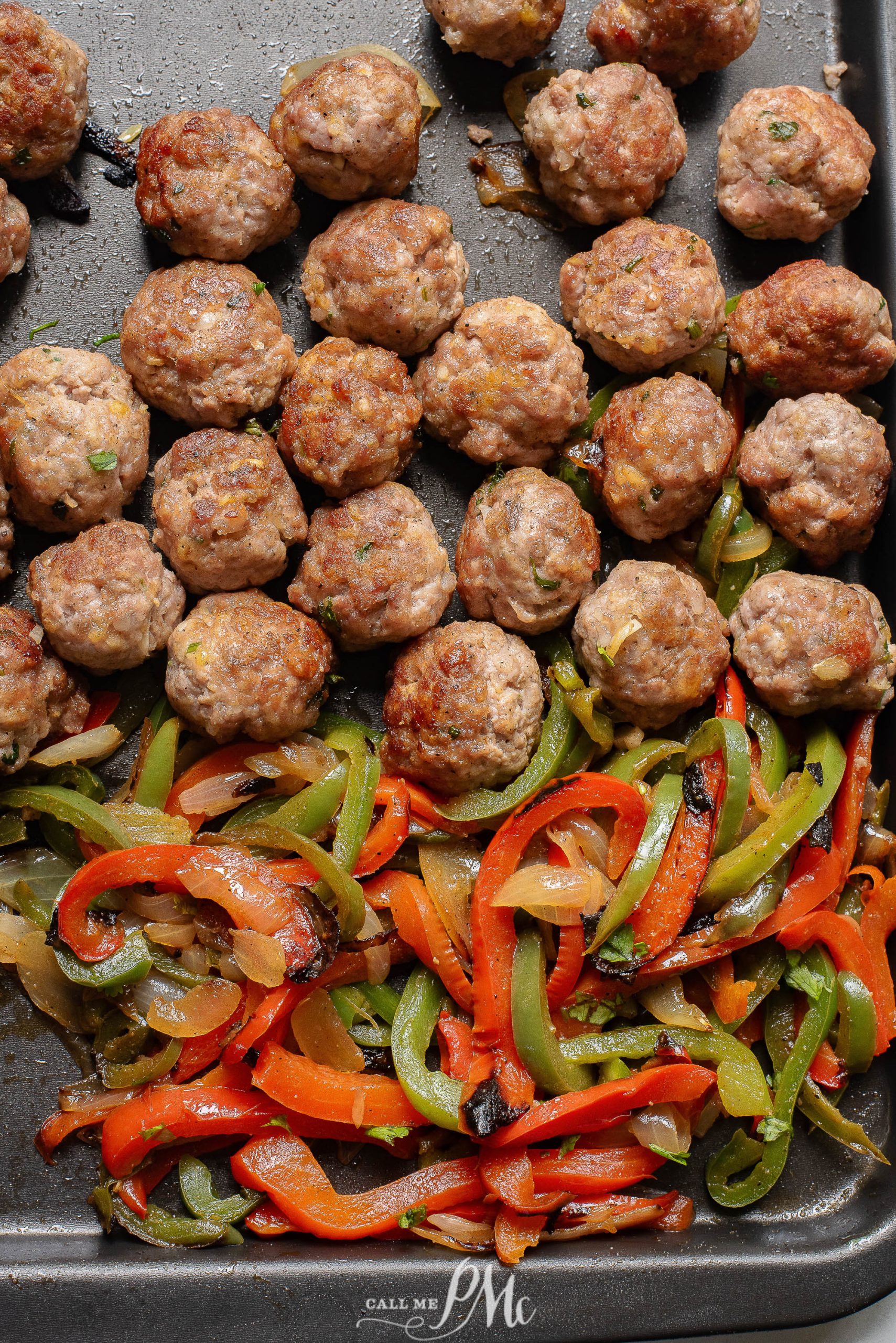 Meatballs and peppers on a baking sheet.