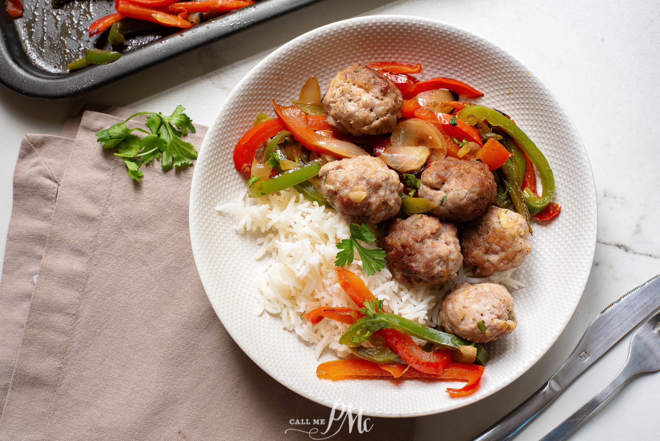A white plate with meatballs, peppers and rice.