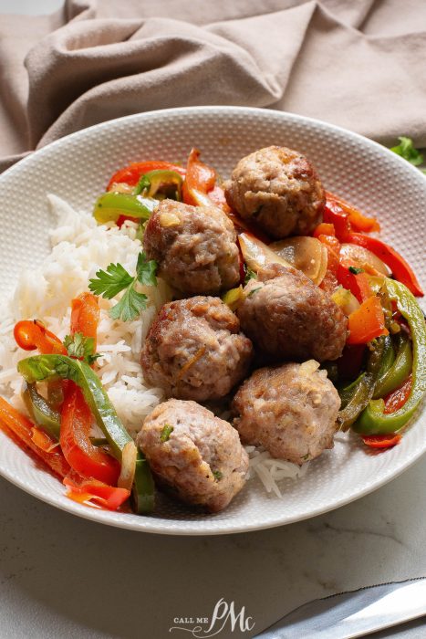 A white plate with meatballs, peppers and rice.