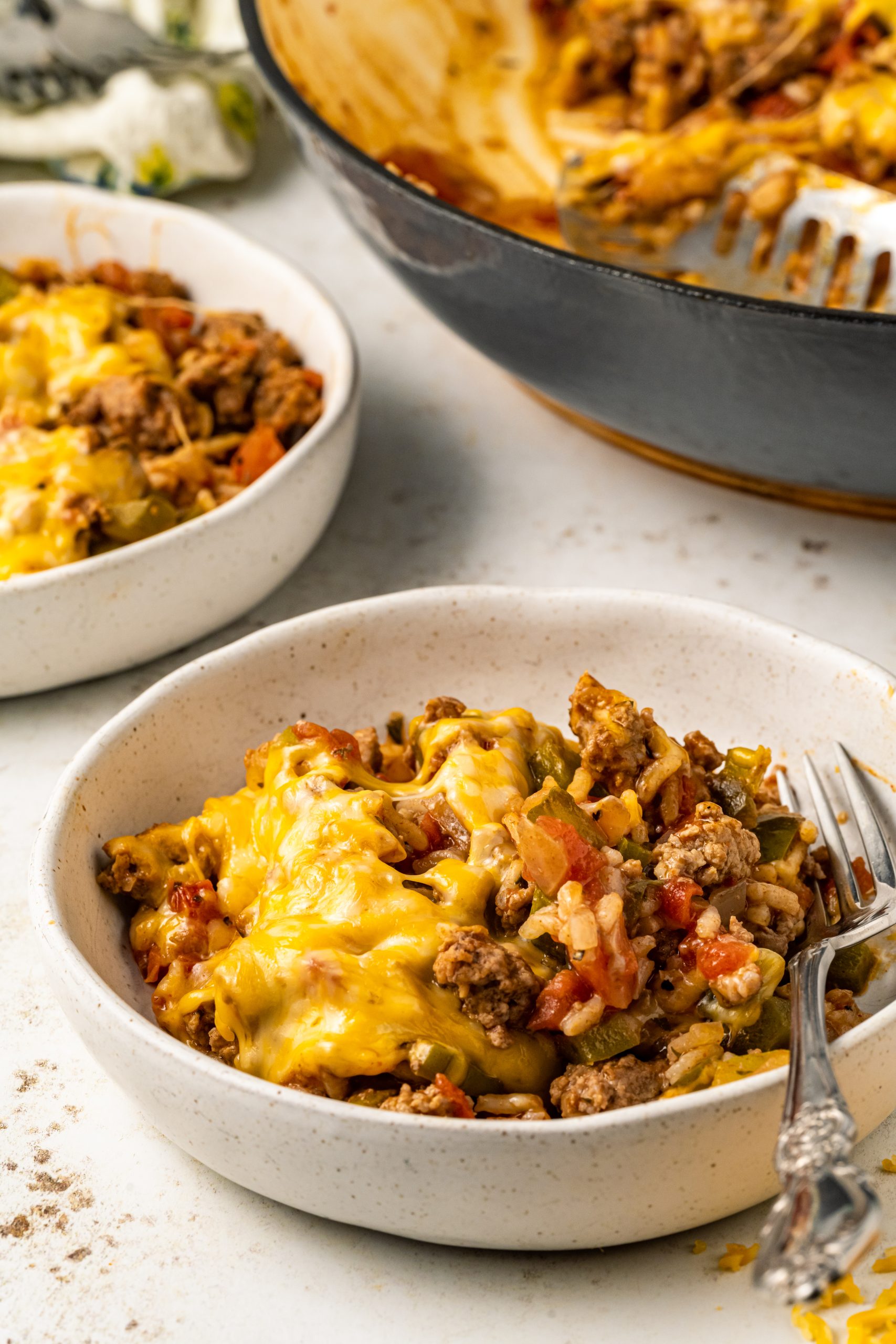 Beef in a bowl with cheese on top of it.