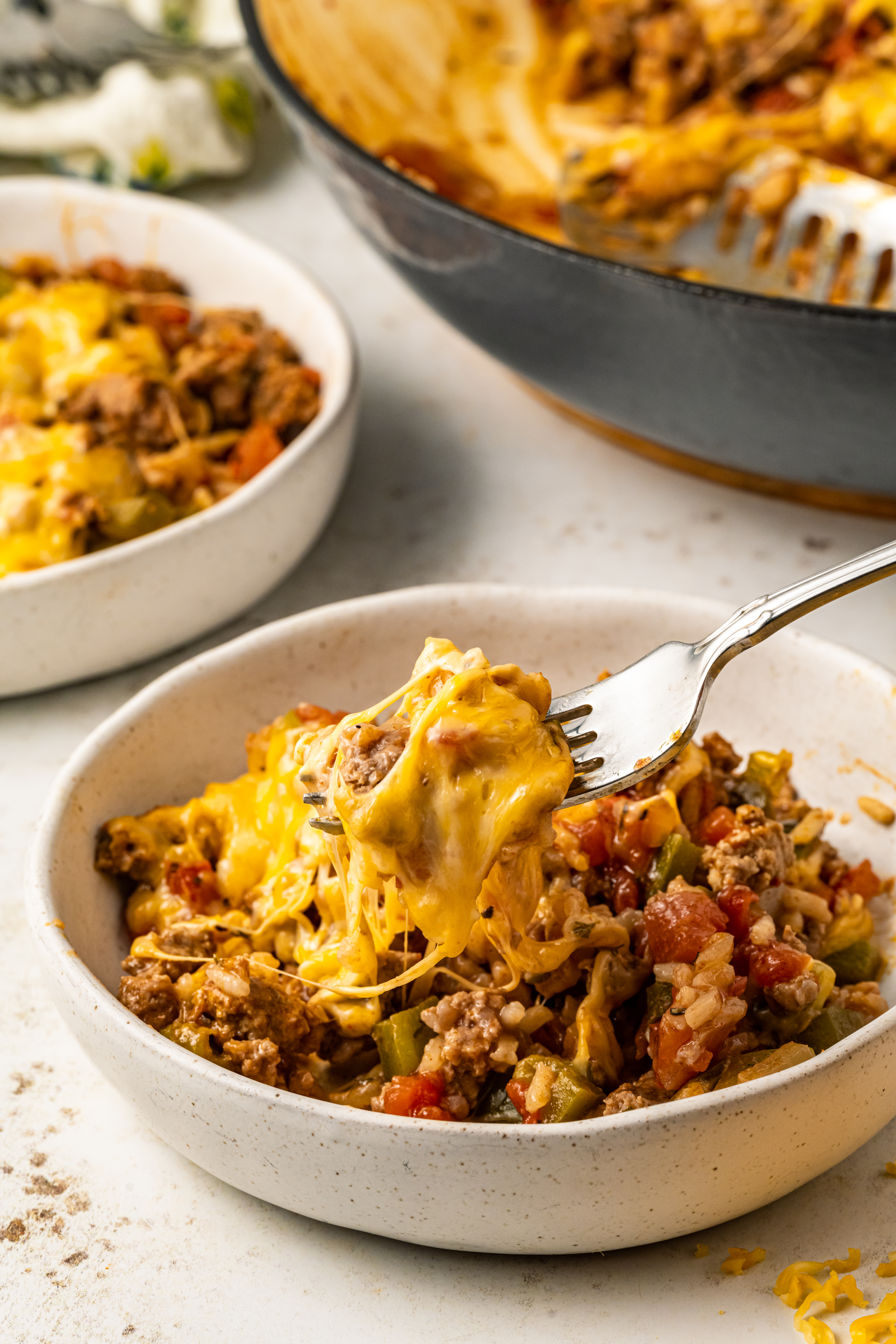 Texas Hash in a bowl with cheese and one bite on a fork.